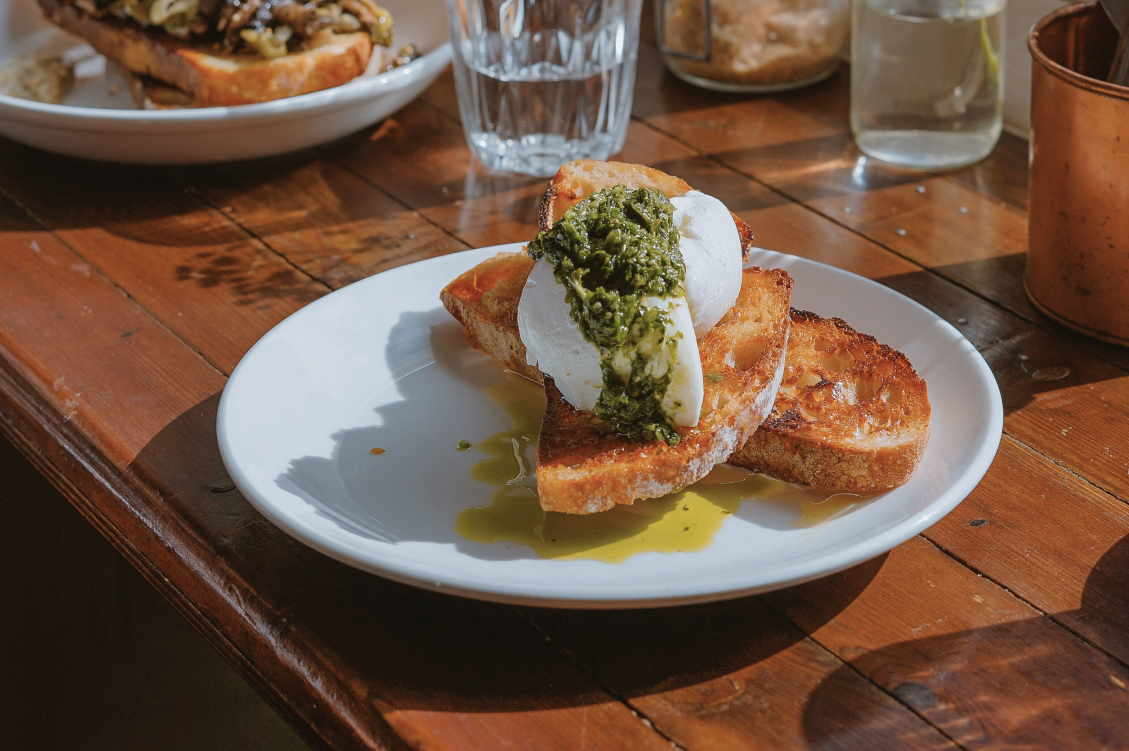 Poached egg on toast with pesto and olive oil