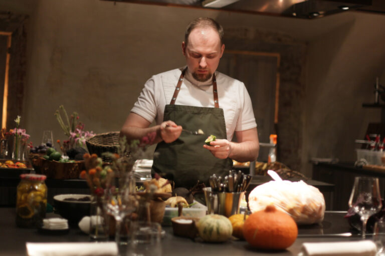 Chef preparing food in a rustic kitchen setting.