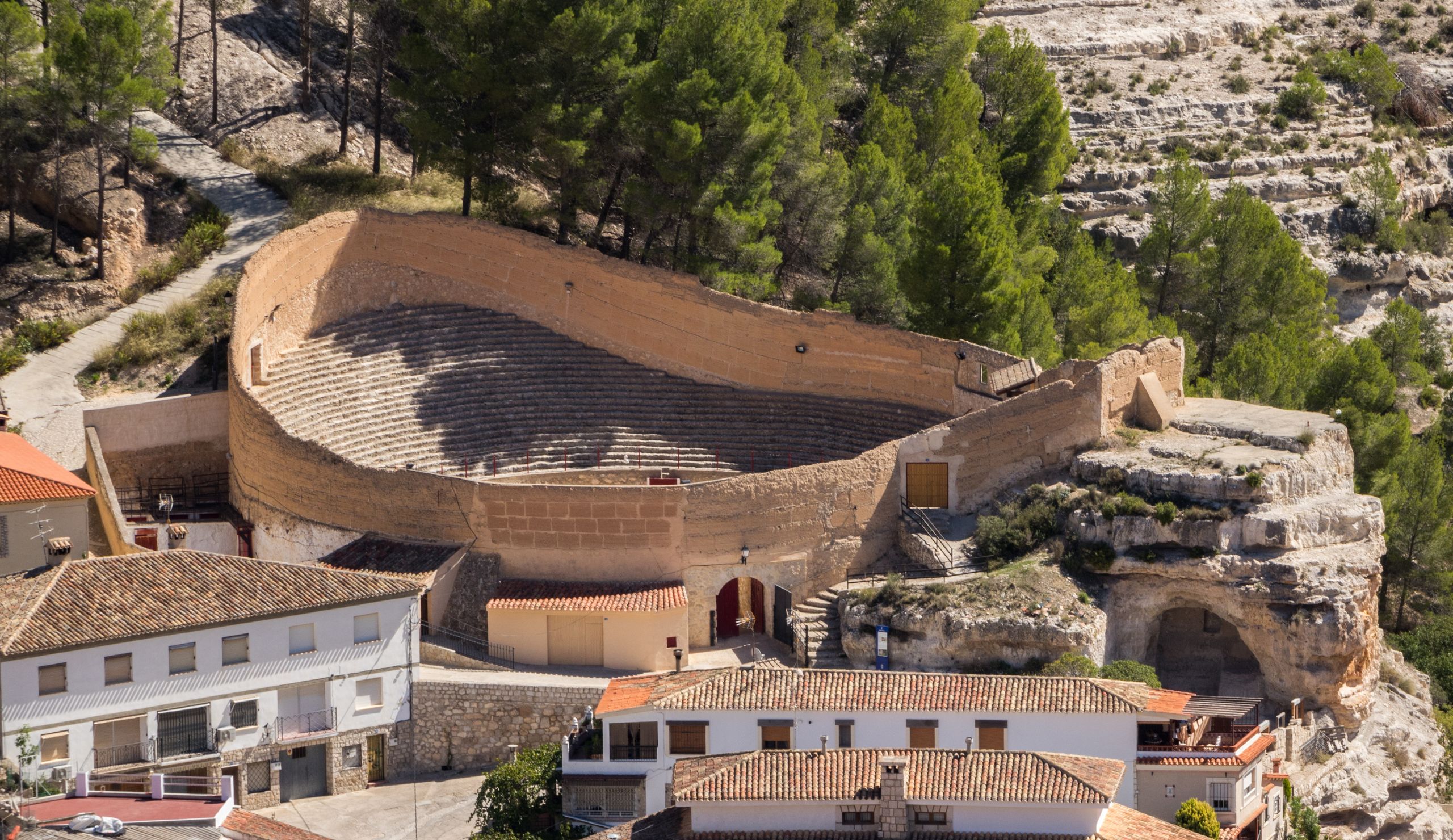 Anfiteatro antiguo en paisaje urbano español.