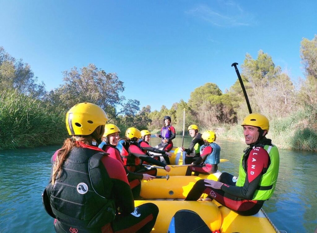 Rafting en río, grupo con cascos amarillos.