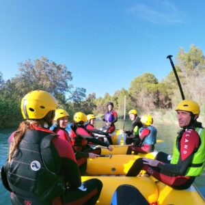 Rafting en río, grupo con cascos amarillos.