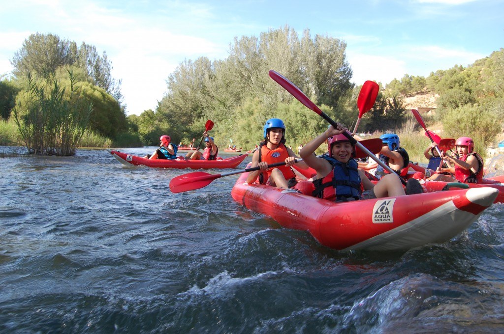 Personas practicando kayak en río.
